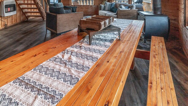 A cozy cabin interior with a wooden interior, a fireplace, a sofa, a dining table, and a staircase. - Disconnect From Technology And Reconnect With Nature - Sleeps 6 (Lake City)