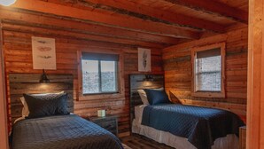 A cabin-style bedroom with two beds, wooden walls, and a window. - Disconnect From Technology And Reconnect With Nature - Sleeps 6 (Lake City)