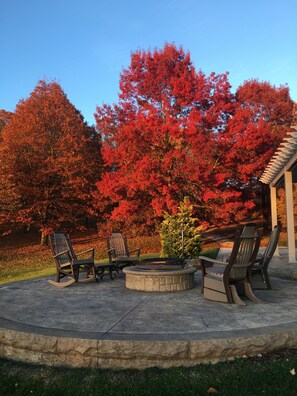 A patio with Adirondack chairs, a fire pit, and a stone fire ring. - Comfortable & Luxurious Barndominium - 30 minutes to Mohican State Park! (Big Prairie)
