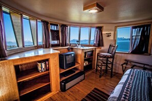 A compact room with a wooden desk, a television, a bookshelf, a chair, and a bed. - Double Eagle House Boat On Land (Homer)