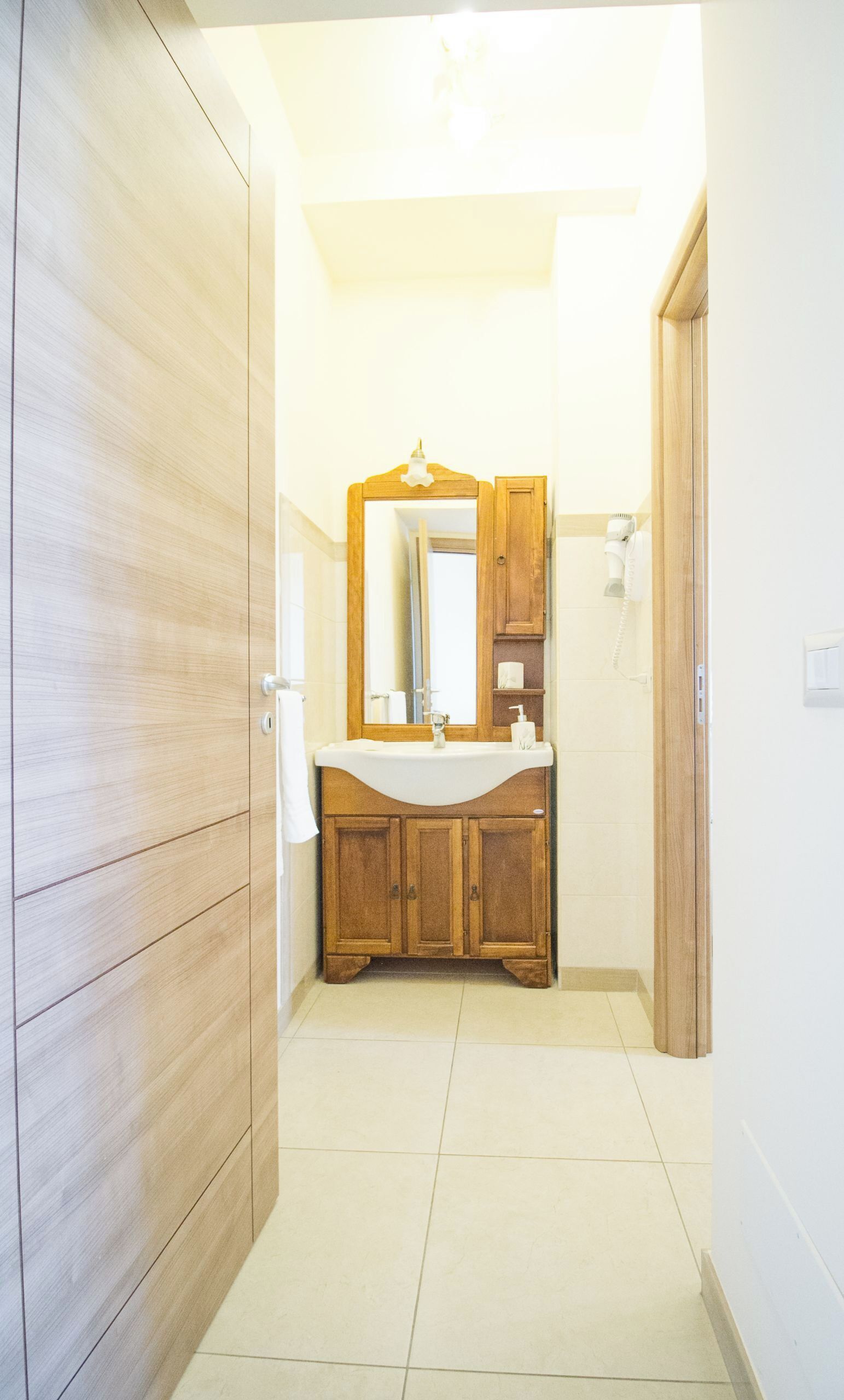 Een badkamer met een houten wastafel, een spiegel en een toilet.