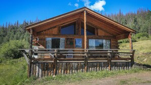 A wooden cabin with a balcony, surrounded by forest. - Zero Technology and100% Nature (Lake City)