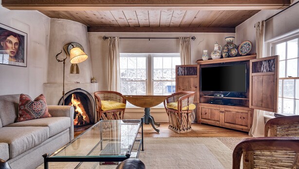 A cozy living room with a fireplace, comfortable seating, a television, and decorative items.