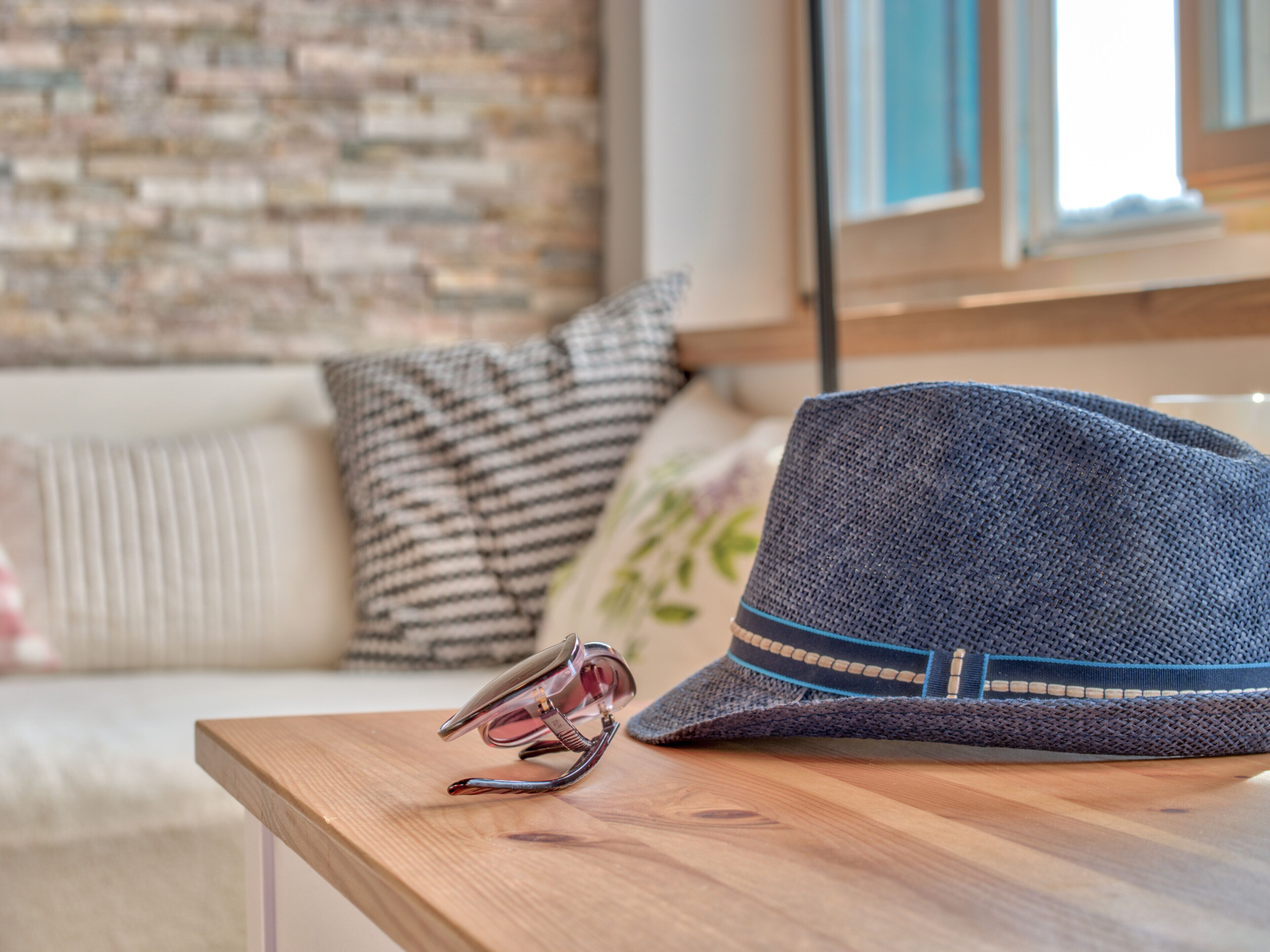 Una mesa de madera con un sombrero azul y un par de gafas de sol.