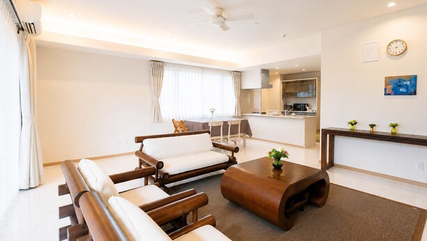 A modern living room with a sofa, a coffee table, and a dining area with a table and chairs.