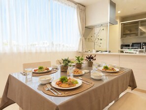 Un coin repas avec une table mise pour le repas, comprenant des assiettes remplies de nourriture, des verres et des couverts.