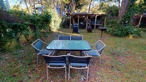 Relax in a serene garden setting with a patio area featuring a table and chairs.