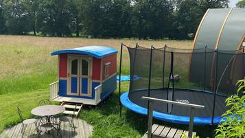 Enjoy a fun-filled day in our outdoor play area, featuring a playhouse, trampoline, and comfortable seating.