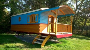 Una casa de madera colorida con un porche y una pequeña escalera que lleva a la entrada.