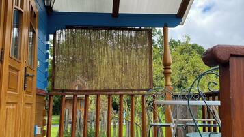 Een houten terras met een pergola en uitzicht op een tuin.