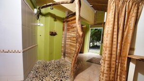 A shower with a wooden slat design, a tiled floor, and a patterned curtain. -  Amazingly Affordable Savings "Rustic Jamaican Vibes" on Ocean Front, Selecluded (St. Mary, Jamaica)