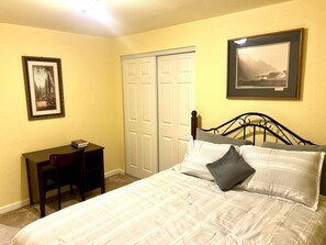 Un dormitorio con una cama, un escritorio y dos puertas.