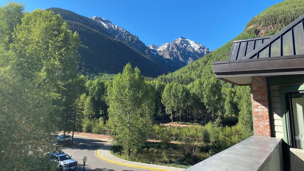 Vista de la montaña con un edificio que tiene un balcón.
