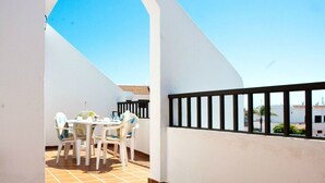 A balcony with a table and chairs, white walls, and a tiled floor. - Sunny 2-Bedrooms With Large Terrace. WiFi (Arona)