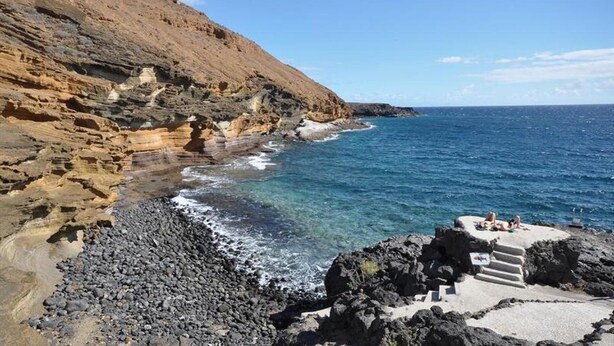 A rocky coastline with clear blue waters and a small staircase leading down to the beach. - Sunny 2-Bedrooms With Large Terrace. WiFi (Arona)
