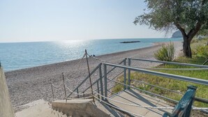 A staircase leading to a beach with a railing and a tree. - Miramare House - Trilo 4 C (Mattinata)