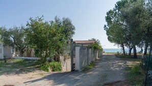 A paved driveway leading to a gated property with a view of the sea. - Miramare House - Trilo 4 C (Mattinata)