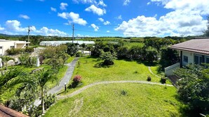 Un quartier résidentiel avec une cour verdoyante, un chemin sinueux et des maisons aux toits en tuiles.
