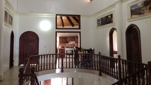 A spacious interior with a high ceiling, wooden beams, and a central staircase. - Luxury retreats, destination weddings, family reunions and social events (Las Terrenas)