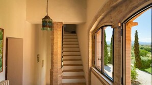 Eine Treppe mit Blick auf einen Garten, einer hängenden Leuchte und einem Fenster mit Ausblick.