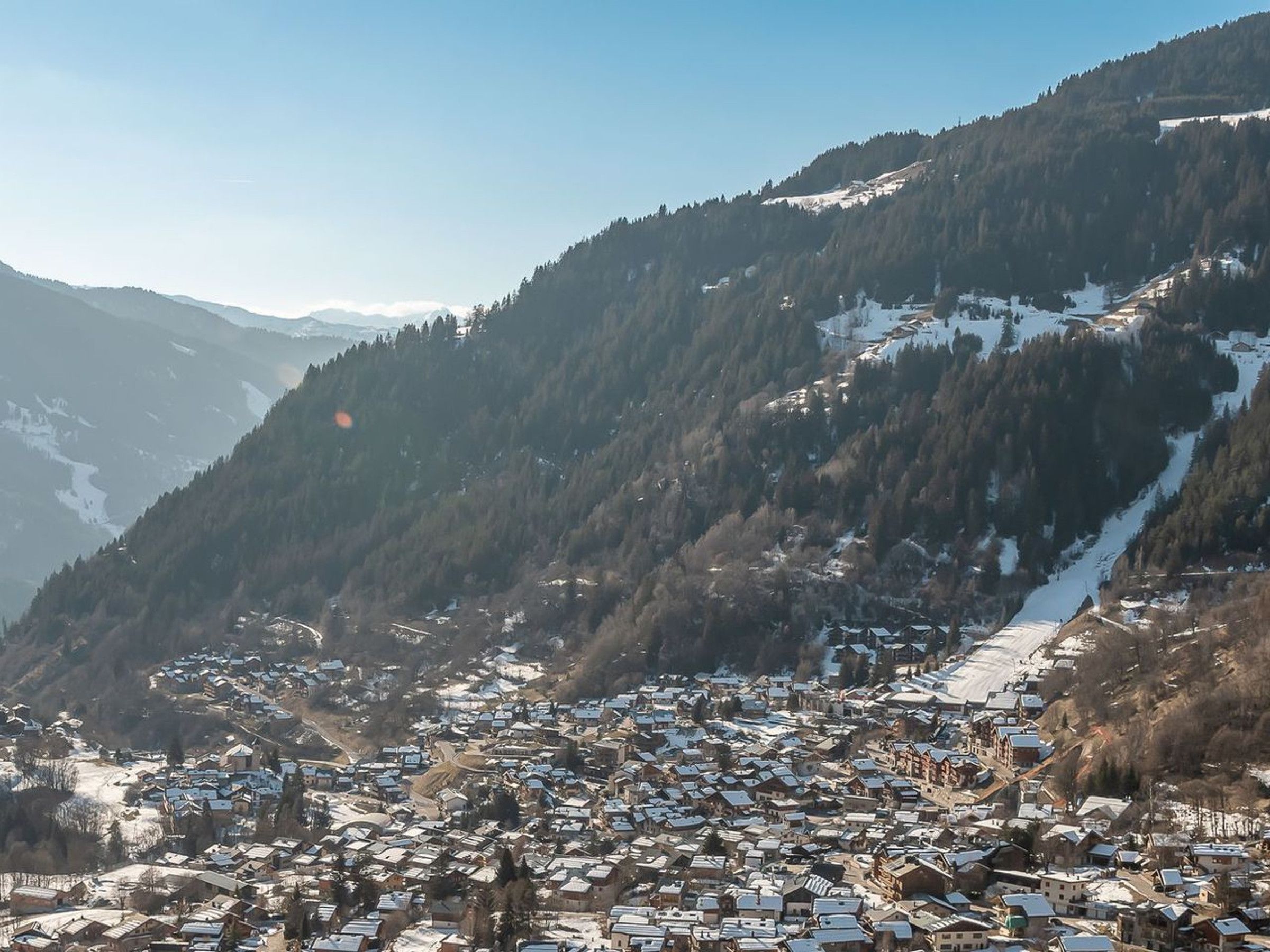 A mountainous village with snow-covered houses and a clear sky.