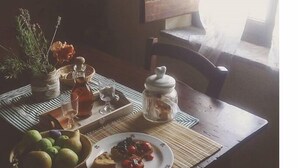 A dining table with a bowl of fruit, a plate of toast with jam, and a jar of jam. - House in the Cortona countryside. Romantic Little House (Fratticciola)