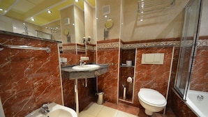 Une salle de bain avec un lavabo, des toilettes et une douche, le tout en marbre.