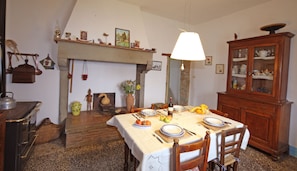 A dining room with a fireplace, wooden furniture, and a table set for a meal. - Farmhouse in the Tuscan countryside (Anghiari - Arezzo)