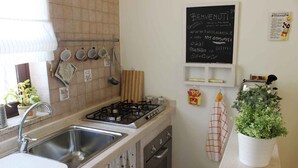A kitchen with a gas stove, sink, and a chalkboard menu. - Vacation House Fiordilavanda (Martina Franca)