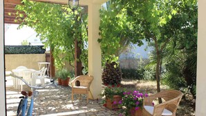 An outdoor patio with stone flooring, wicker furniture, and potted plants. - Vacation House Fiordilavanda (Martina Franca)