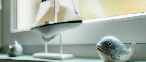 A model ship and a fish figurine on a shelf.