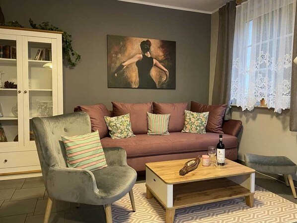 A living room with a sofa, armchair, and coffee table.
