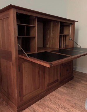 A wooden cabinet with multiple compartments and a pull-out shelf.