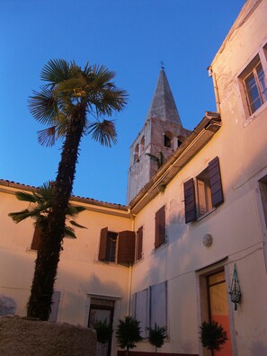 Un bâtiment doté d’un clocher, de palmiers et d’une porte.