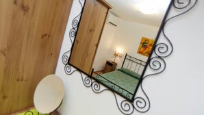 Ein Schlafzimmer mit einem Bett, einem Nachttisch, einer Lampe und einem Bild an der Wand.