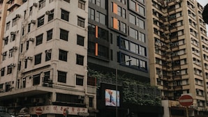 A multi-story building with a modern architectural design, featuring a mix of glass and concrete facades. - Le Hoteru (Kowloon)