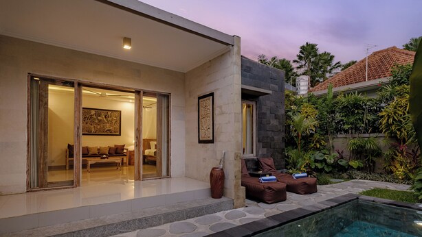 A modern house with a glass-enclosed patio, a pool, and a well-maintained garden. - Puri Sedana Ubud Villa (Ubud)