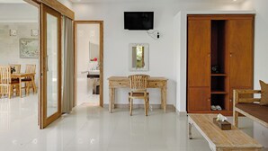 A room with a wooden desk, chair, and a television mounted on the wall. - Puri Sedana Ubud Villa (Ubud)