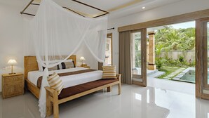 A spacious bedroom with a large bed, a bench, and a view of a garden and pool. - Puri Sedana Ubud Villa (Ubud)