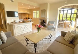 Un amplio espacio de estar con sofá, mesa de centro y chimenea.