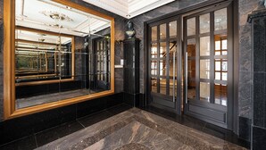 Eine prachtvolle Lobby mit einem großen Spiegel, Marmorboden und einer Statue.