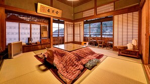 Ein traditioneller japanischer Raum mit Tatami-Böden, einem niedrigen Tisch und Schiebetüren.