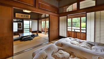 Ein traditioneller japanischer Raum mit Tatami-Bodenbelag, einem niedrigen Tisch und verschiebbaren Türen.