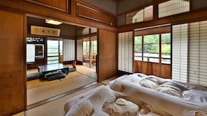 Una habitación japonesa tradicional con suelo de tatami, una mesa baja y puertas correderas.