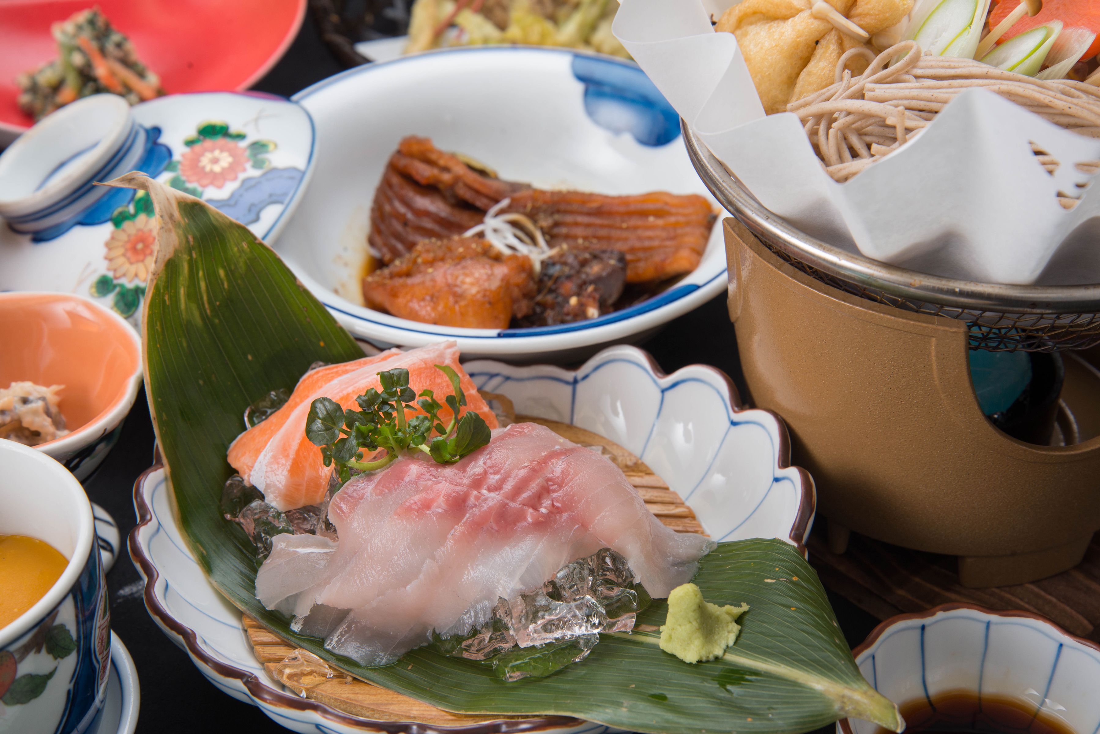 A variety of dishes on a table, including sushi and other Asian cuisine.