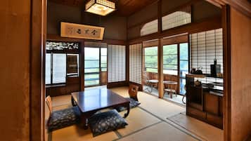 Ein traditioneller japanischer Raum mit Tatami-Böden, einem niedrigen Tisch und Shoji-Schirmwänden.