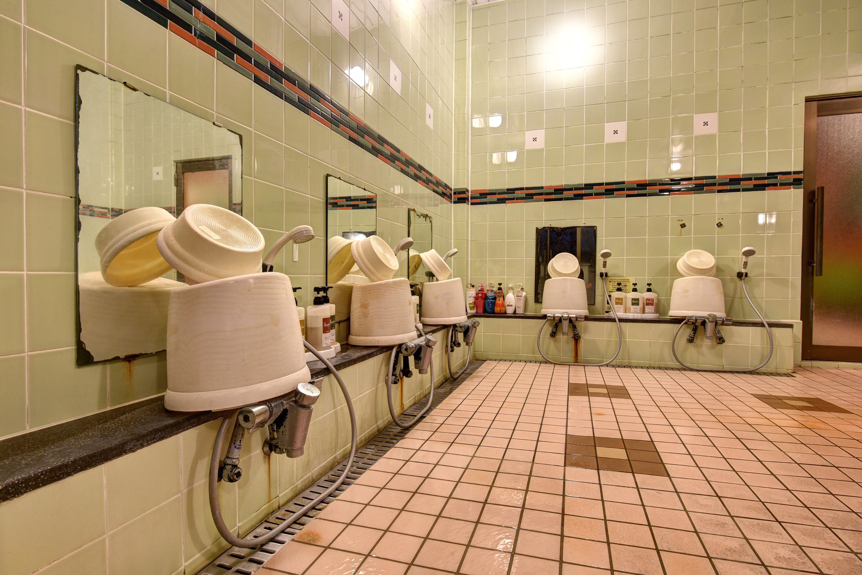 Des toilettes publiques équipées de plusieurs lavabos, de miroirs et de sèche-mains.