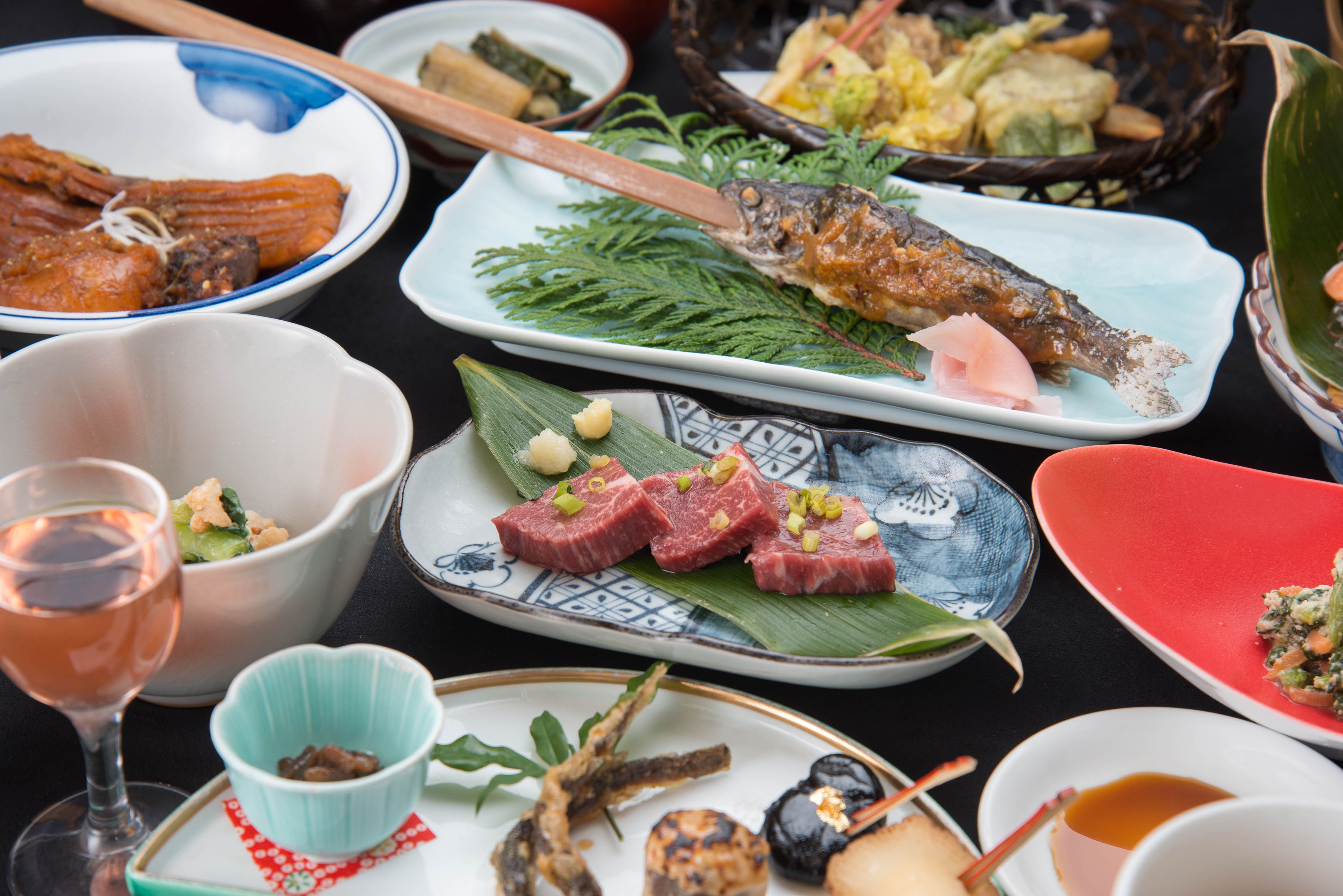 A variety of dishes on a table, including fish, meat, and vegetables.
