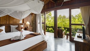 A bedroom with a wooden bed, white bedding, a canopy, and a view of greenery outside. - Moringa Ubud Villa (Ubud)