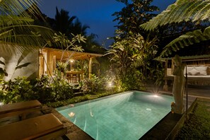 A rectangular swimming pool surrounded by lush tropical vegetation and wooden structures. - Moringa Ubud Villa (Ubud)